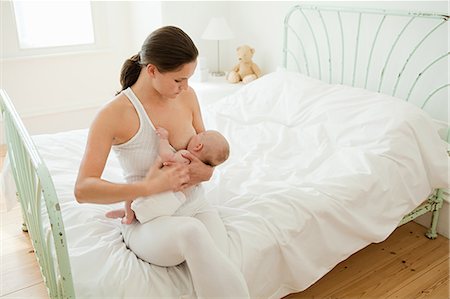 sucking - Mother breast feeding baby on bed Stock Photo - Premium Royalty-Free, Code: 614-03684097