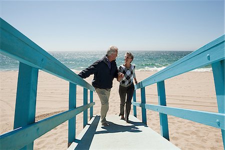 seniors with sky - Mature couple walking on beach walkway Stock Photo - Premium Royalty-Free, Code: 614-03697126