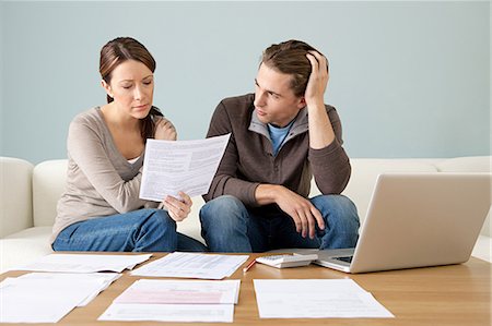 Young couple using computer and doing paperwork Stock Photo - Premium Royalty-Free, Code: 614-03697142