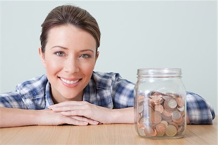 Young woman with jar of coins Stock Photo - Premium Royalty-Free, Code: 614-03697159