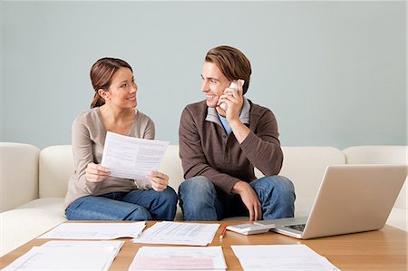 Jeune couple à l'aide d'ordinateur et de faire de la paperasse Photographie de stock - Premium Libres de Droits, Code: 614-03697198