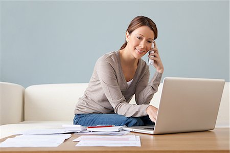 Jeune femme au téléphone avec ordinateur portable Photographie de stock - Premium Libres de Droits, Code: 614-03697191