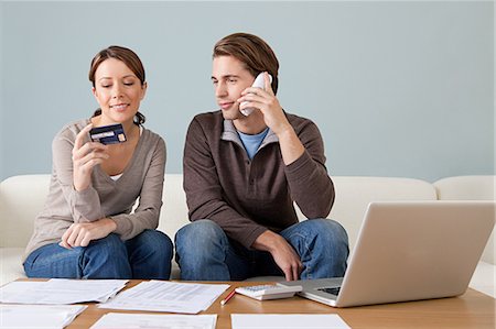 phone young woman card - Young couple using computer and doing paperwork Stock Photo - Premium Royalty-Free, Code: 614-03697193