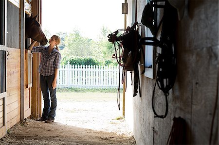 stable - Mid adult woman with horse in stable Stock Photo - Premium Royalty-Free, Code: 614-03697353