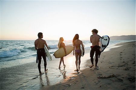 summer sport - Vue arrière des surfeurs sur la plage au coucher du soleil Photographie de stock - Premium Libres de Droits, Code: 614-03697604