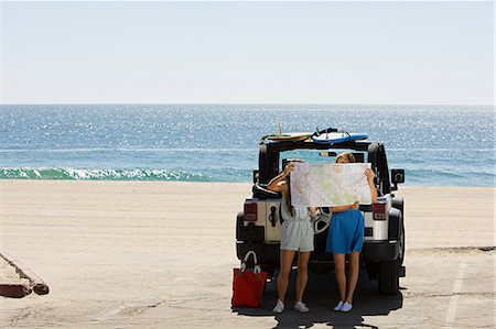 people lost on a map - Young women by vehicle, looking at map Stock Photo - Premium Royalty-Free, Code: 614-03697658