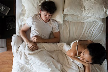 people from above view - Man sleeping and woman restless in bed Stock Photo - Premium Royalty-Free, Code: 614-03697668