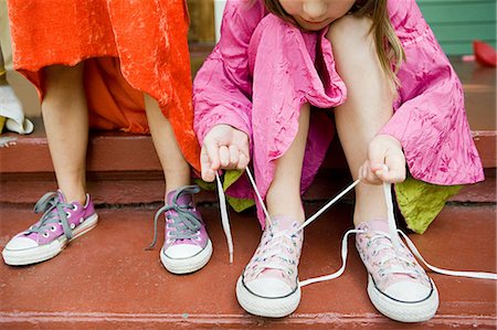 Two girls, one tying up shoelace Foto de stock - Sin royalties Premium, Código: 614-03747790