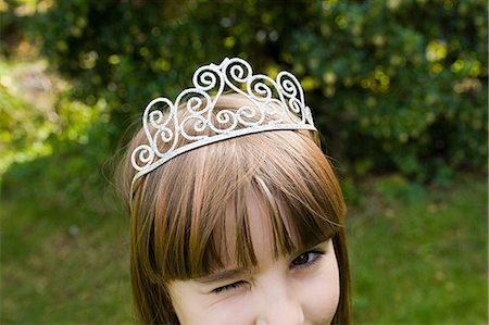 Girl wearing tiara and winking Stock Photo - Premium Royalty-Free, Code: 614-03747805