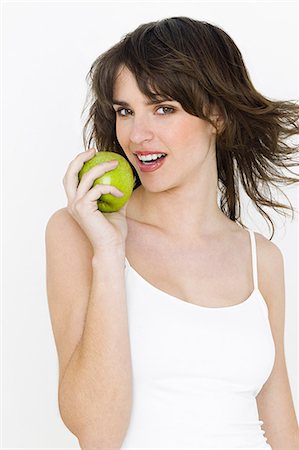 Portrait of young brunette woman eating apple Stock Photo - Premium Royalty-Free, Code: 614-03763698