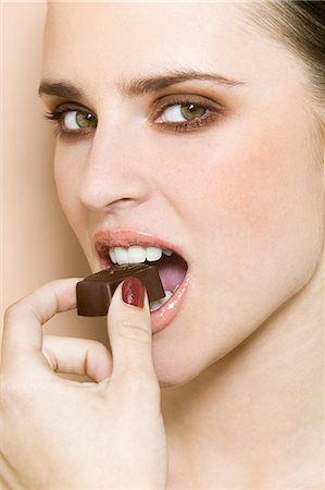 Young woman biting chocolate Foto de stock - Sin royalties Premium, Código: 614-03763707