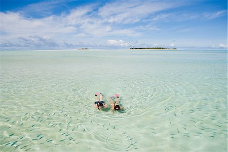 Mid adult couple snorkeling and looking at fish Foto de stock - Royalty Free Premium, Número: 614-03763736