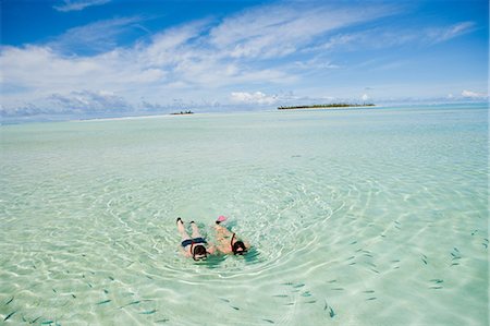 Mid adult couple snorkeling and looking at fish Foto de stock - Royalty Free Premium, Número: 614-03763737