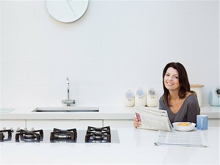 Mature woman having breakfast, reading newspaper Foto de stock - Sin royalties Premium, Código: 614-03763830