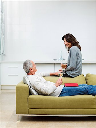side view relaxing couch - Mature couple sitting on sofa with wine Foto de stock - Sin royalties Premium, Código: 614-03763833