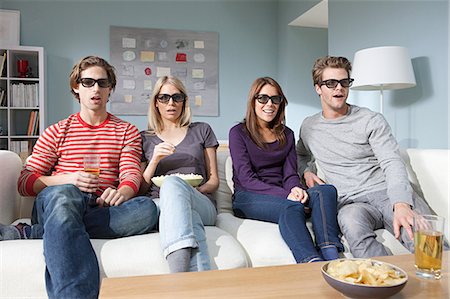 Four friends watching 3d movie at home Stock Photo - Premium Royalty-Free, Code: 614-03784101