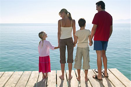 remera - Rear view of family standing on jetty Foto de stock - Sin royalties Premium, Código: 614-03783460