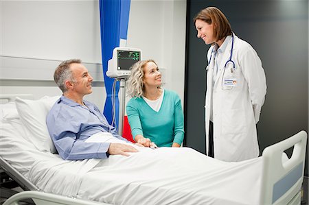 Wife visiting husband in hospital, talking to doctor Stock Photo - Premium Royalty-Free, Code: 614-03783630