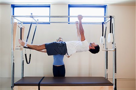 Man doing pilates with instructor Stock Photo - Premium Royalty-Free, Code: 614-03783784