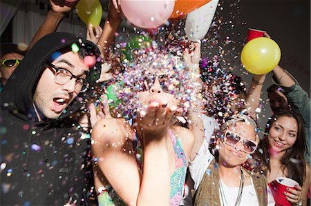 Woman blowing glitter at party Stock Photo - Premium Royalty-Free, Code: 614-03818513