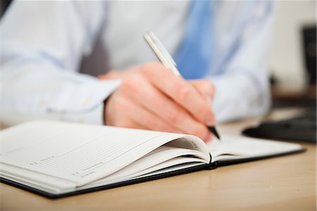 Office worker writing in diary Stock Photo - Premium Royalty-Free, Code: 614-03818812