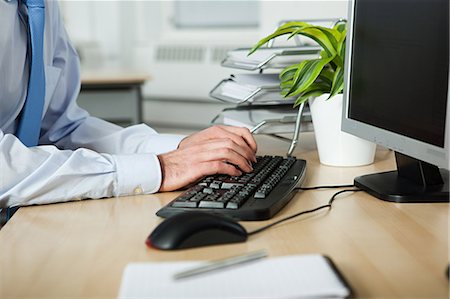 Office worker using computer Stock Photo - Premium Royalty-Free, Code: 614-03818823