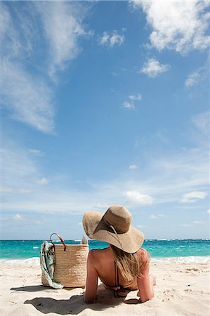 Woman lying on sandy beach, Mustique, Grenadine Islands Stock Photo - Premium Royalty-Free, Code: 614-03902667