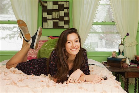 Teenage girl lying on bed, portrait Stock Photo - Premium Royalty-Free, Code: 614-03902849