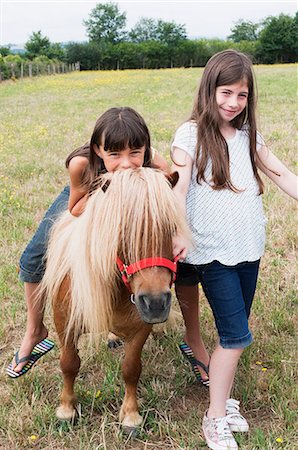poni - Girls with pony in field Foto de stock - Sin royalties Premium, Código: 614-03903191
