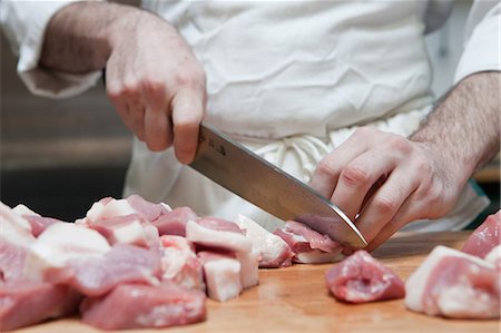 Butcher chopping meat into chunks Stock Photo - Premium Royalty-Free, Code: 614-03903611
