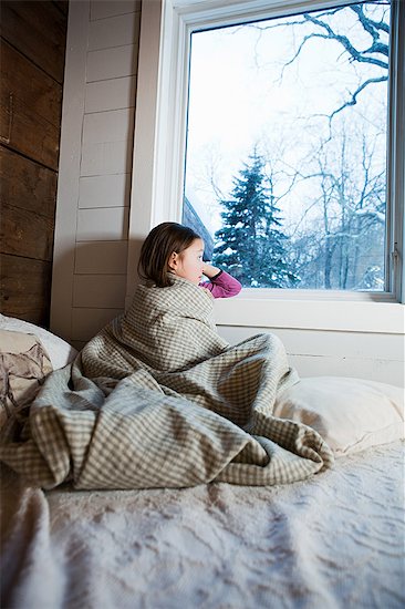 Young girl sitting on bed looking through window Foto de stock - Sin royalties Premium, Código de la imagen: 614-03981327