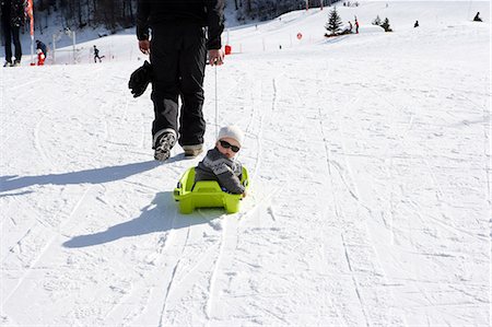 slittino - Father pulling son on sledge Fotografie stock - Premium Royalty-Free, Codice: 614-03981416