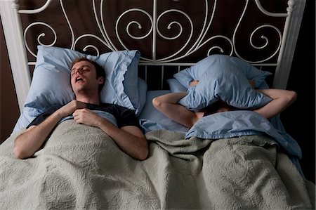 snoring couple - Jeune homme, ronflement, femme couvrant le visage avec oreiller Photographie de stock - Premium Libres de Droits, Code: 614-03981519