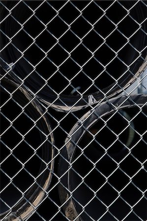 Pipes behind wire mesh fence Stock Photo - Premium Royalty-Free, Code: 614-03981828