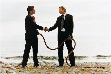simsearch:6102-03859327,k - Two businessmen shaking hands on a beach, holding a rope. Stock Photo - Premium Royalty-Free, Code: 6102-03748234
