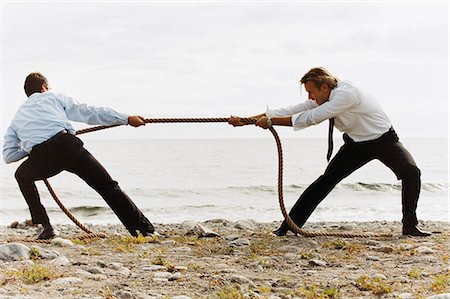 simsearch:6102-06336804,k - Two men in a tug of war. Foto de stock - Sin royalties Premium, Código: 6102-03748235