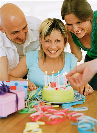 simsearch:6102-03748559,k - Trois personnes et un gâteau d'anniversaire. Photographie de stock - Premium Libres de Droits, Code: 6102-03748564