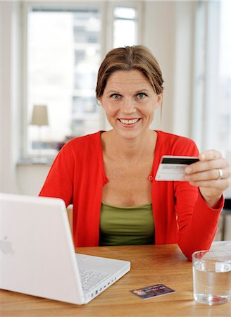 A woman with a credit card by a computer. Stock Photo - Premium Royalty-Free, Code: 6102-03748781