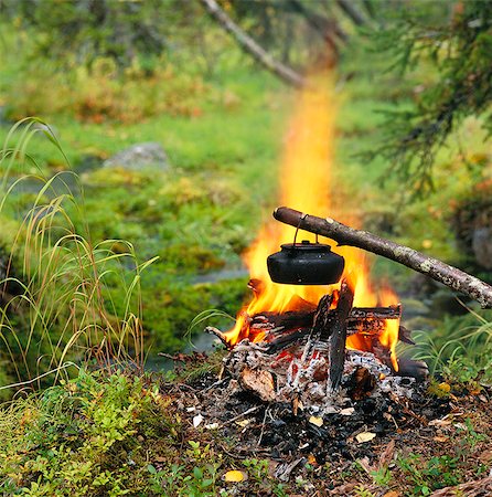 A pot hanging over a camp fire. Stock Photo - Premium Royalty-Free, Code: 6102-03749048