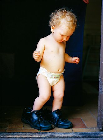 diapered girls - A girl trying on big shoes. Stock Photo - Premium Royalty-Free, Code: 6102-03749797