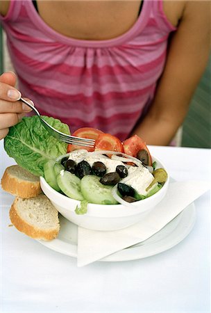 A woman eating Greek salad. Stock Photo - Premium Royalty-Free, Code: 6102-03749714