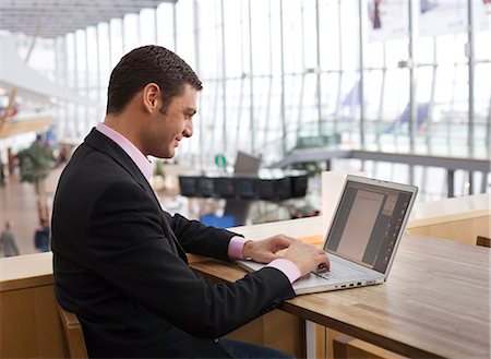 A man working on a laptop on an airport. Stock Photo - Premium Royalty-Free, Code: 6102-03749951