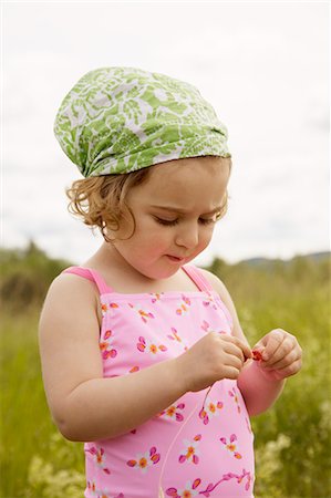 A girl making a straw of wild strawberries. Stock Photo - Premium Royalty-Free, Code: 6102-03750484