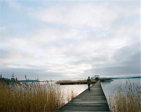 sad and quiet woman - A woman walking on a jetty. Stock Photo - Premium Royalty-Free, Code: 6102-03750414