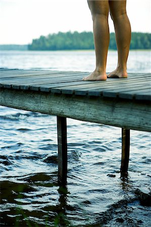 dock on a lake summer feet - The legs of a woman standing on a jetty. Stock Photo - Premium Royalty-Free, Code: 6102-03750566