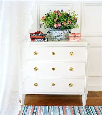 Interior with white chest of drawers and lace curtain. Stock Photo - Premium Royalty-Free, Code: 6102-03750685