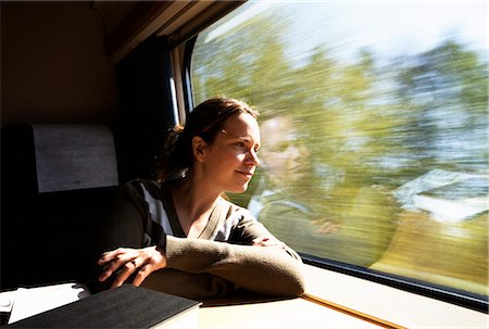 Woman looking out the window from a train. Stock Photo - Premium Royalty-Free, Code: 6102-03751004