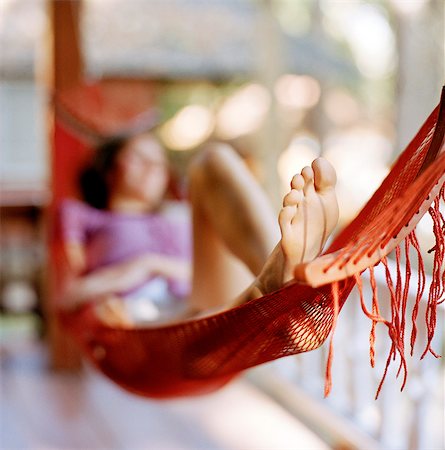 A woman laying in a hammock. Stock Photo - Premium Royalty-Free, Code: 6102-03751106