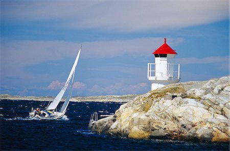 simsearch:6102-06470448,k - Sailing-boat on the ocean, lighthouse on a rock, Vastkusten, Sweden. Stock Photo - Premium Royalty-Free, Code: 6102-03751129