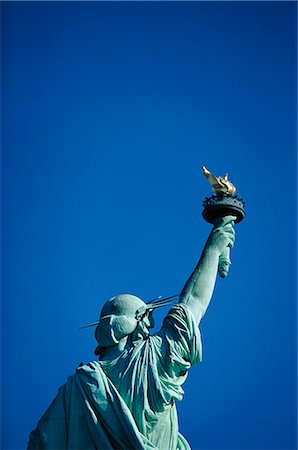 estatua de la libertad - Rear view of Statue of Liberty against blue sky Foto de stock - Sin royalties Premium, Código: 6102-03858977